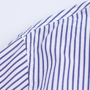 Detailed close-up of shoulder stitching and blue striped fabric on a casual shirt