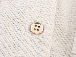 Gros plan détaillé du tissu kaki de la robe cargo avec bouton classique et texture lin