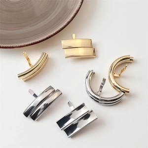 Detailed view of polished gold and silver irregular lava metal hair clips with back hooks