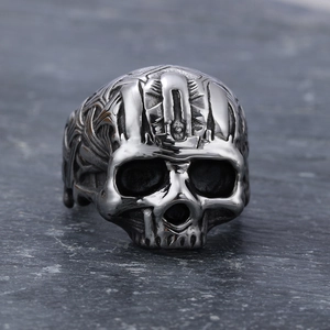 Vintage stainless steel skull ring with gothic relief details on dark stone background