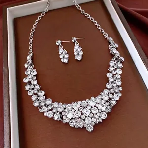 Elegant silver diamond jewelry set with necklace and drop earrings on a leather tray