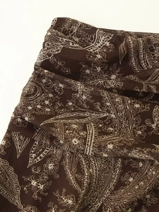 Detailed macro view of the pleated chiffon fabric with vintage paisley print pattern
