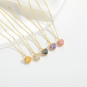 Detail of five multi-colored heart-cut gemstone pendants on golden necklaces