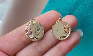 Macro view of gold celestial pendants with white zircon and blue sapphire stones
