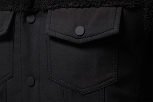 Dettaglio giacca in twill nero con tasca a patta stile workwear e colletto in shearling