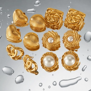 Close-up of gold-plated stainless steel earrings with textured patterns and pearl accents