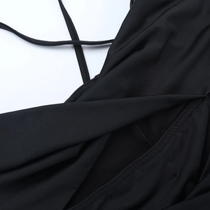Détail de l'encolure croisée et des coutures sur cette robe moulante noire élégante