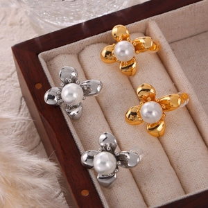 Elegant gold and silver floral stud earrings with pearls in a wooden jewelry box