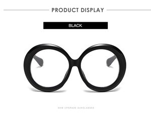 Detail view of large black round frame glasses with polished glossy finish