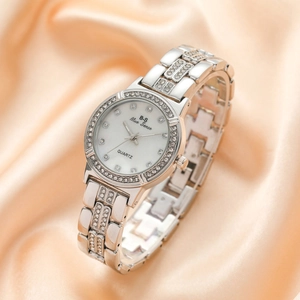 Elegant women's silver quartz watch with sparkling rhinestones on champagne satin background
