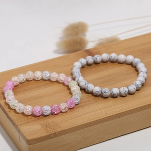 Detail of 8mm gradient cat-eye and marble stone beaded bracelets on wood stand