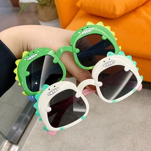 Cute green and white dinosaur cartoon sunglasses for kids with dark protective lenses