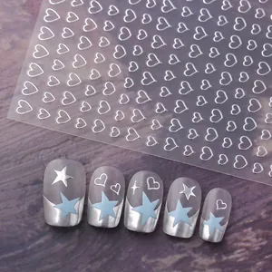 Hollow silver heart and star nail art stickers on blue and grey manicured nails