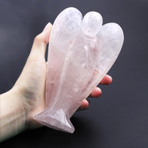 Macro shot of 2-inch translucent rose quartz angel figurine held in hand for scale
