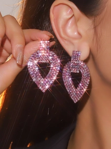 Macro detail of luxury long tassel earrings with sparkling pink and purple rhinestones