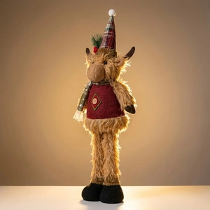 Detail of Christmas highland cow plush featuring red vest and festive plaid hat decor