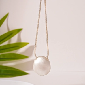 Detail view of silver matte pebble pendant on a sleek snake chain necklace