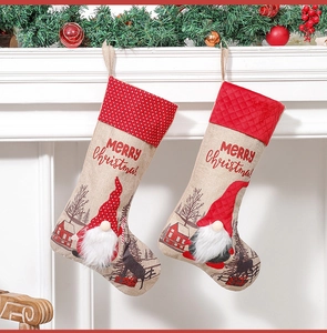 Christmas stockings with gnomes hanging on a white fireplace with festive green garland