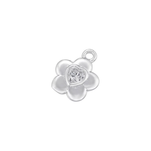 Macro shot of a silver five-petal flower charm with heart-shaped cubic zirconia center