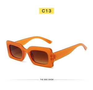 Close-up of retro orange rectangle sunglasses with brown gradient lenses and wide temples