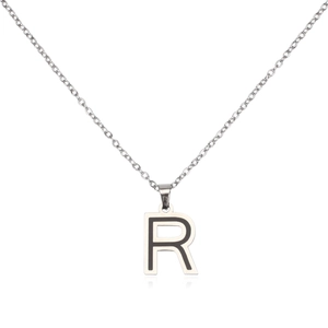 Macro shot of silver stainless steel pendant with letter R and black enamel inlay
