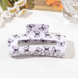 Detail of white butterfly hair claw clip featuring purple prints and a glossy resin finish