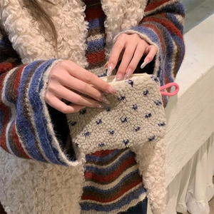 Close-up of white plush mini coin purse with pink zipper held in hand for scale