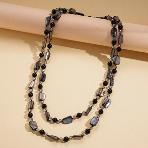 Détail du collier double rang avec perles noires et éclats de nacre foncée élégants
