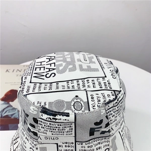 Detailed close-up of retro newspaper print canvas bucket hat with artistic text pattern