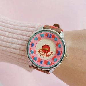 Close-up of cute pink cookie-themed watch dial with silicone strap on wrist