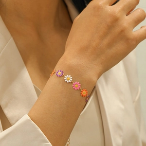 Elegant gold chain bracelet featuring colorful daisy flower charms for women