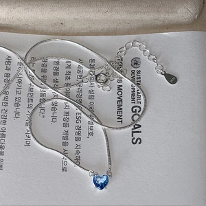 Macro shot of S925 sterling silver heart pendant with dark blue zircon on a fine chain