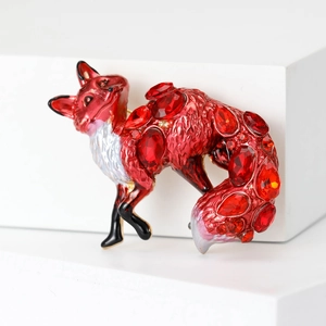 Close-up of a red rhinestone fox brooch with gold alloy accents on a white background