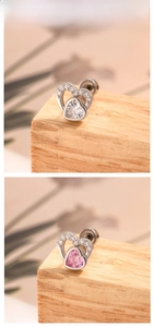 Detail of heart-shaped zircon earrings in silver-tone metal with pavé setting