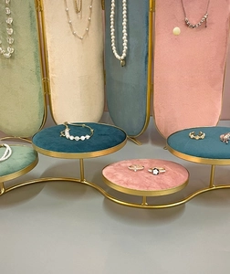 Detalle del expositor de joyas de varios niveles con marcos dorados y bandejas de terciopelo