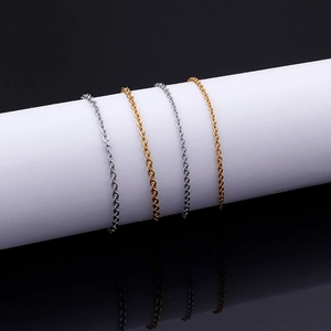 Polished stainless steel cross chains in gold and silver finish on a display stand