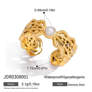 Vue détaillée d'une bague en acier doré ornée d'une perle centrale et de strass