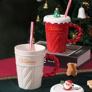 Detail of red and white knitted texture ceramic mugs with Christmas tree lids and straws