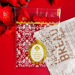 Close-up of transparent cookie bag with white floral pattern and gold foil label