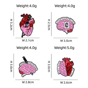 Set of four creative heart and brain enamel pins with anatomical dagger designs