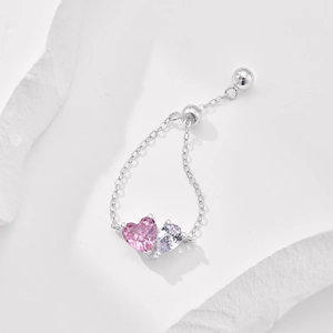 Detail of S925 silver double heart ring with pink and purple zircon stones on white stone
