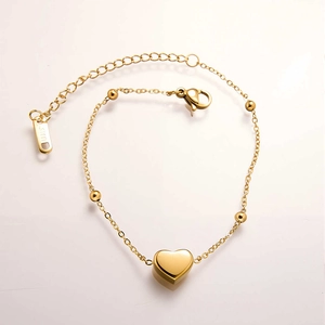 Detail of gold heart pendant bracelet with polished beads and lobster clasp closure