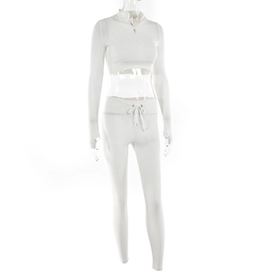 Detail of white ribbed two-piece set featuring half-zip crop top and high waist leggings