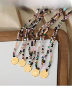 Macro view of multi-color natural stone necklaces with gold Love Angel embossed pendants
