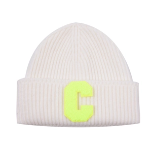 Close-up of cream knit beanie with vibrant neon yellow letter C patch detail