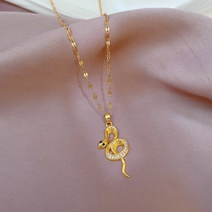 Vue macro du pendentif serpent doré avec micro-cristaux sertis sur tissu en soie