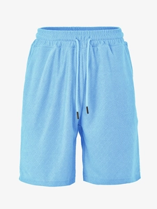 Detail of light blue waffle texture shorts with elastic waistband and black drawstrings
