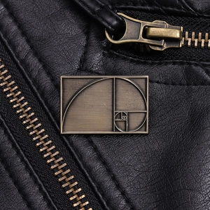 Detail of bronze Fibonacci spiral brooch on black leather jacket zipper with metallic texture