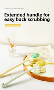 Detailed view of the long handle shower brush with dense bristles and floral pattern design