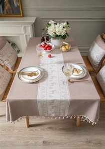 Detail of jacquard deer pattern and fringe edge on beige christmas tablecloth